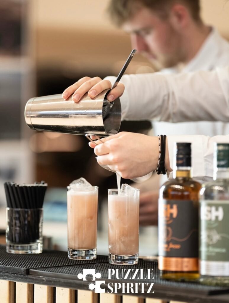 To alkoholfri pinke cocktails. En mand i en hvid skjorte